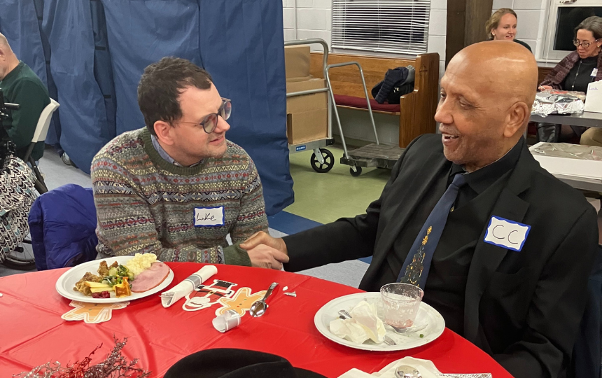 Two men share a friendly conversation while sitting at a festive table