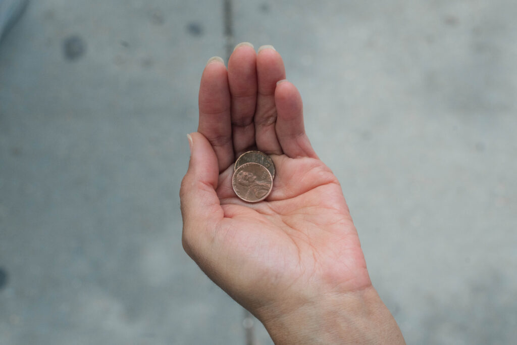 Eileen's black hand is palmed upward, gracefully cupping a copper penny.