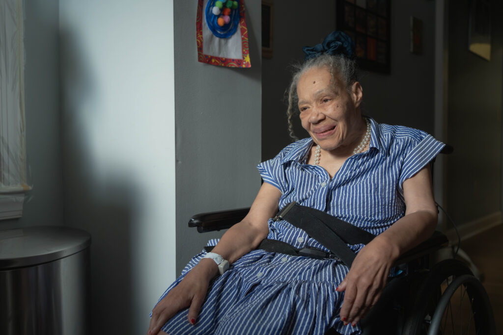 Debora wearing a blue and white striped dress, glowing in the afternoon sunlight washing through her bedroom window.