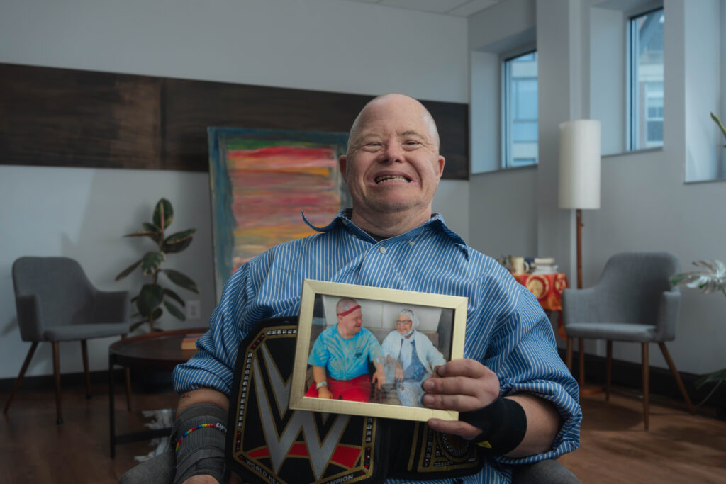 Fritz poses with a photograph of him and his mom during his listening tour interview.