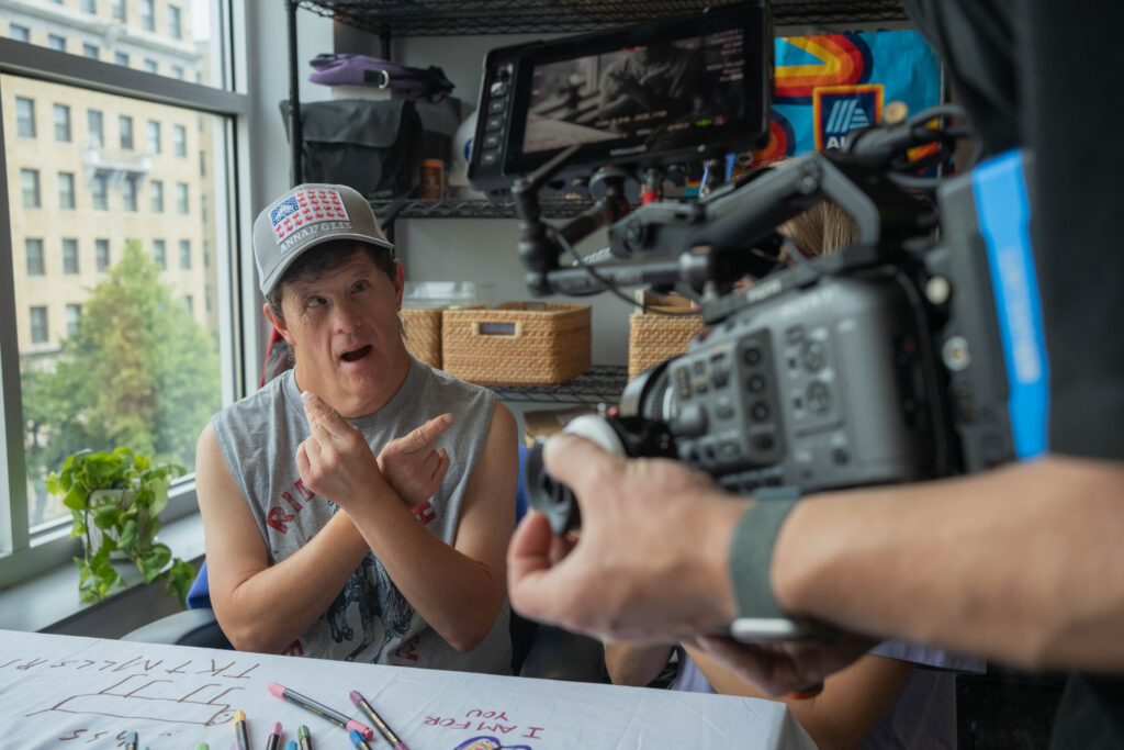 Ricky snaps his finger to his song while being videoed by the film crew.